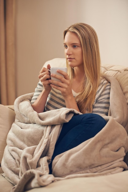 Relaxing with a cup of java Shot of an attractive young woman drinking a coffee at home