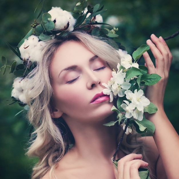 屋外の花とリラックスした女性。白いリンゴの花を持つ美しい女性