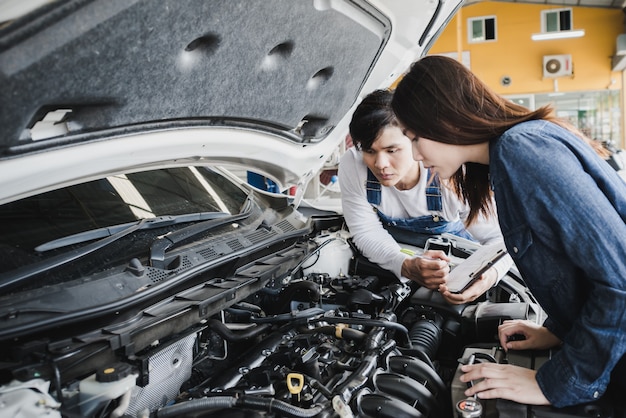 Reliable auto mechanic talking to a female customer 