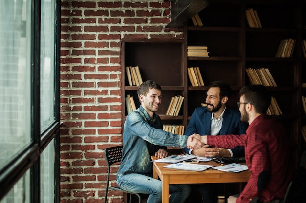 Reliable business partners shake hands after discussing the contract for the work space in the office