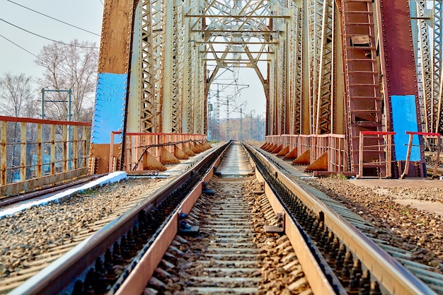 Reliable railway bridge, against the backdrop of beautiful nature and blue sky. Looking through the bridge. Backgound.