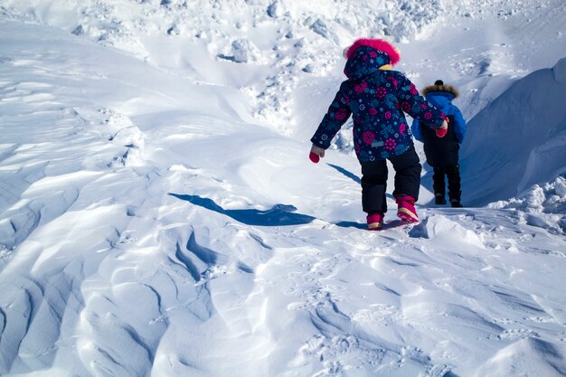 Reliëf op sneeuwdek nadat een sneeuwstorm kinderen de berg afdalen