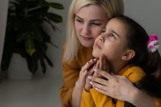 Religieus christelijk meisje en haar moeder bidden thuis.