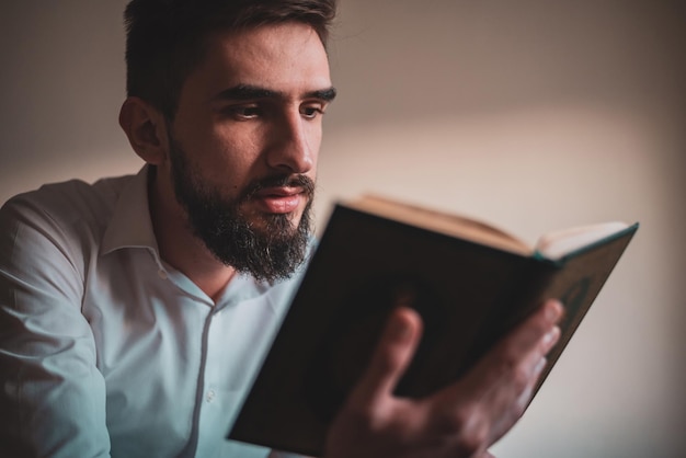 Foto religieuze arabische moslim man die de heilige koran thuis leest