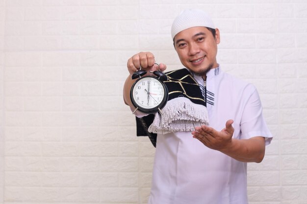 Religieuze Aziatische moslimman met wekkertijdherinnering voor iftar tijdens ramadan