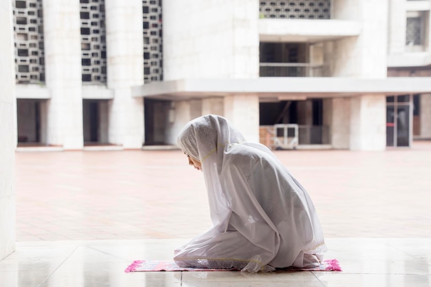 Religieuze vrouw die salat doet in de Istiqlal-moskee