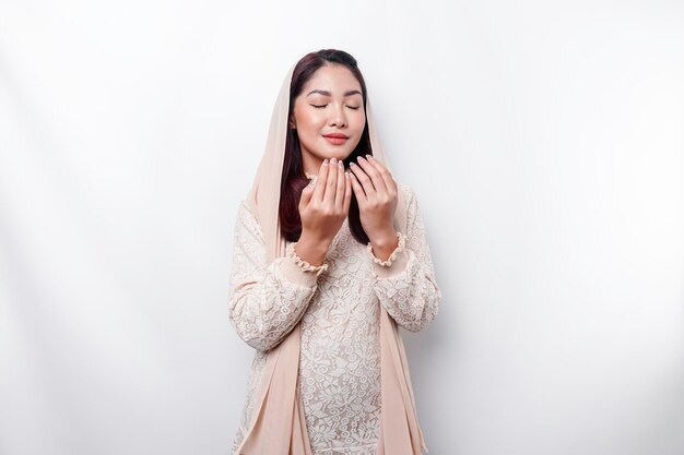 Religious beautiful Asian Muslim girl wearing a headscarf praying to God