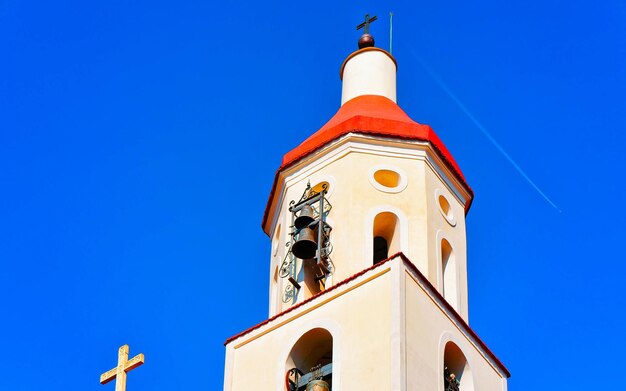 Religious belfy on St Saint Matthew Church in Agerola, Bomerano district on Amalfi coast in Italy on Summer. Mediterranean cathedral with blue sky. Bell tower building architecture. Italian religion.