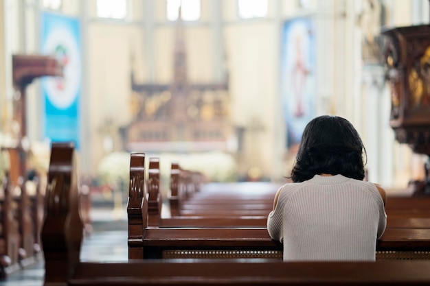 Foto donna religiosa che prega nella chiesa