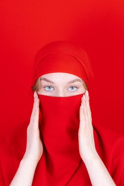 Религиозная женщина в красном хиджабе демонстрирует протест