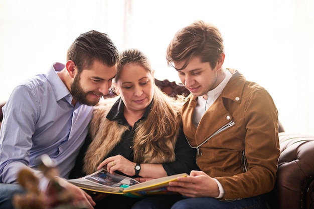 Reminiscing on some great memories Cropped shot of a mother and her sons looking at a photo album together at home