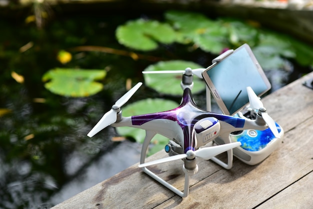 Remote control and drone on table garden