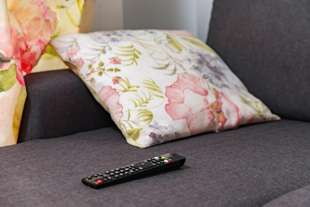 The remote control from the TV lies on the couch