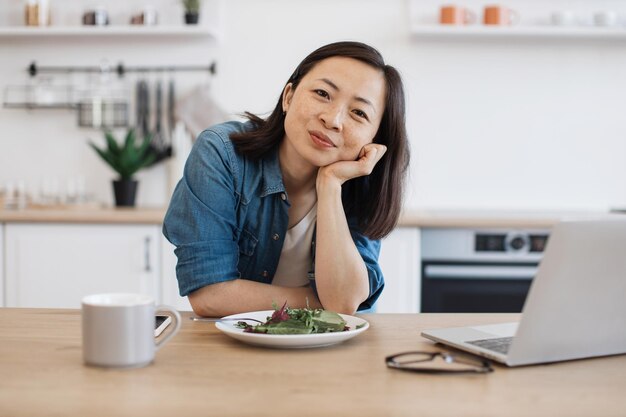 노트북과 러드와 함께 테이블에 앉아 있는 원격 직원