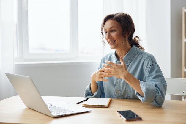 Remote job distance communication concept smiling cheerful\
happy cute awesome curly businesswoman speak in online meeting\
using laptop at home office copy space for ad