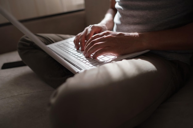 Remote Job Man aan het werk op Laptop zittend op de Bank thuis