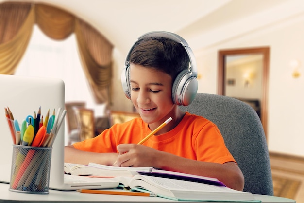 Remote learning concept with boy using laptop at the desk