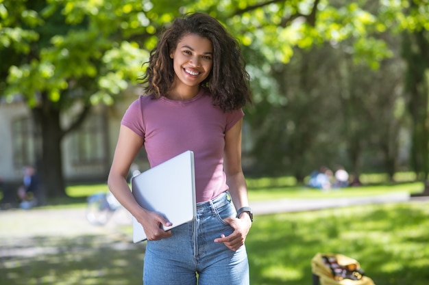 Remote studying. A pretty dark-skinned girl studying on the park