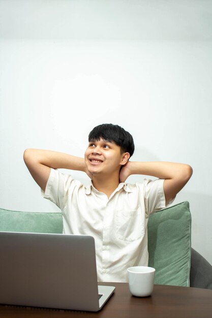 Remote work concept Male freelancer relaxing and drink coffee after working on laptop at home