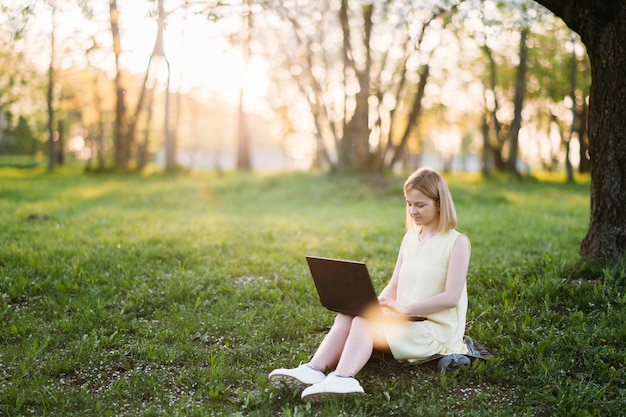 remote work young woman works with a laptop in a park in nature Selfisolation and internet work