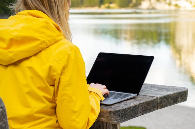 Photo remote worker relaxing near the lake and using laptop