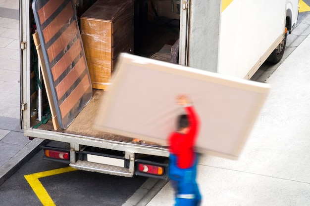 Photo removal truck and unrecognizable delivery man working in city street