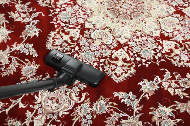 Photo removing dirt from carpet with modern vacuum cleaner above view space for text