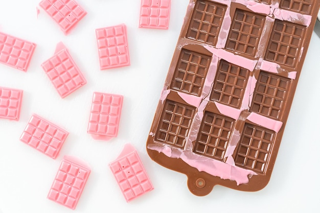 Removing mini pink chocolates from silicone chocolate mold.