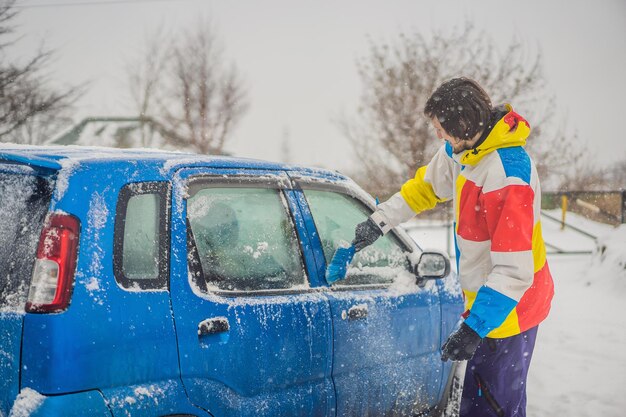 Removing snow from car with a brush