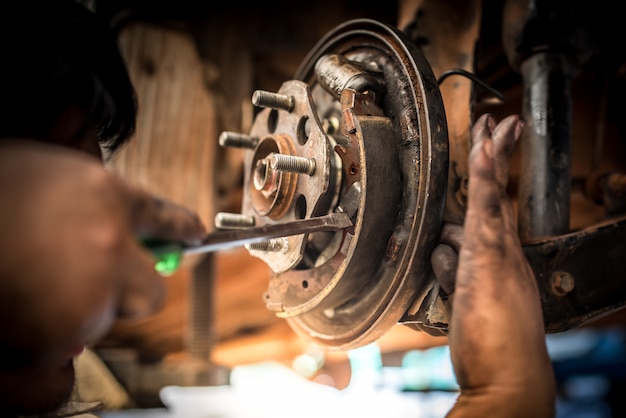 Remreparatie of inspecties van remsystemen en de vervanging van nieuwe remblokken van monteurs die auto-remblokken in autoreparatiewerkplaatsen vervangen