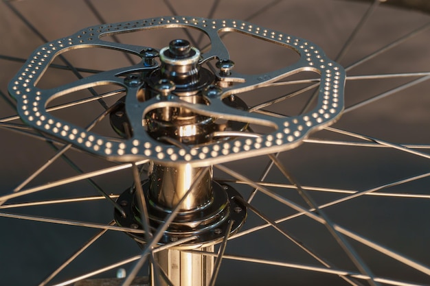 Foto remschijf op een fietswiel close-up een fietsmonteur in de werkplaats met gereedschap in zijn hand fietsreparatie in de studio op een zwarte achtergrond details van een mountainbike