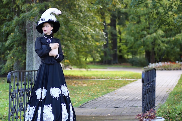 Renaissance vrouw met boek op de brug in het park