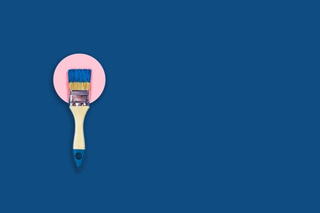Renovation concept classic blue background with paint brush on pink paper circle