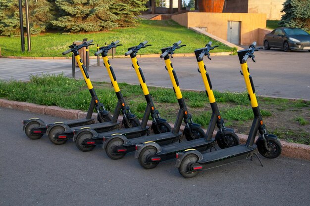 Rental scooters stand in a row on a city street