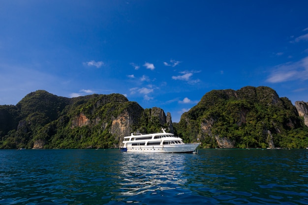 Rental white boat on the sea high season travel tourist and mountain cliff with blue sky on phi phi island kra bi Thailand