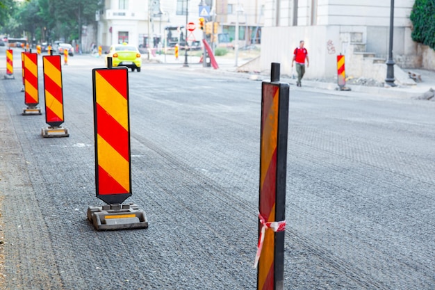 Foto riparazione della strada asfaltata della città sostituzione dell'asfalto e della recinzione con segnali stradali