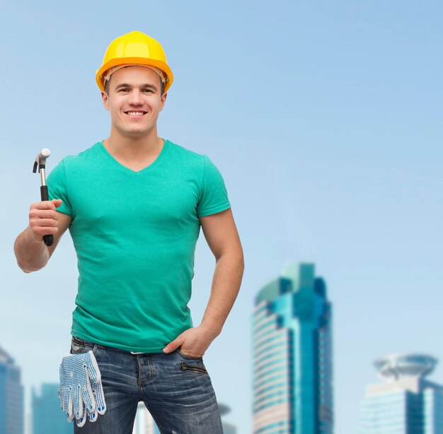 repair, construction and maintenance concept - smiling male manual worker in protective helmet with hammer