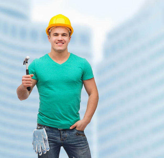 repair, construction and maintenance concept - smiling male manual worker in protective helmet with hammer