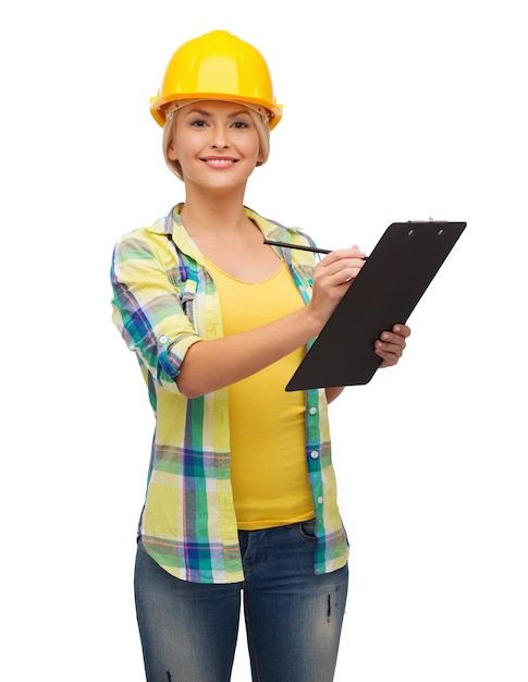 repair, construction and maintenance concept - smiling woman in helmet with clipboard