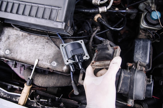 Riparare le bobine di accensione degli elettricisti in un'auto, i cavi dell'alta tensione.