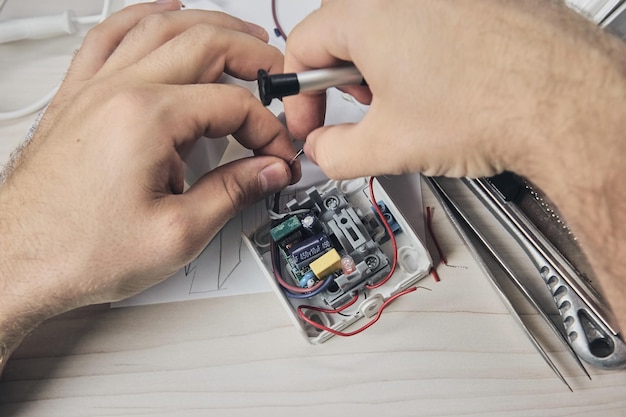 Repair of electronic devices, tin soldering parts. hands of man\
holding screwdriver. computer circuit board