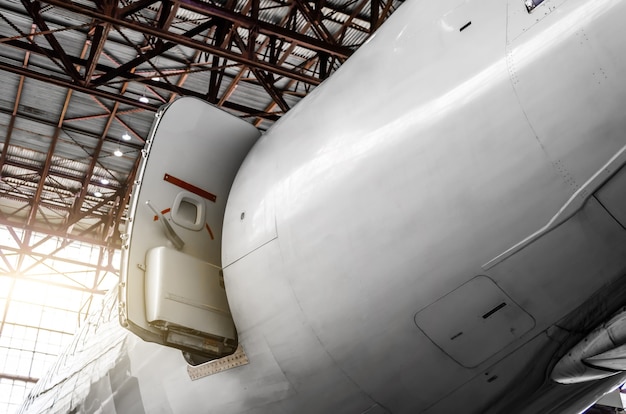 Repair and maintenance of the entrance-exit door to the aircraft at the tail in the hangar.