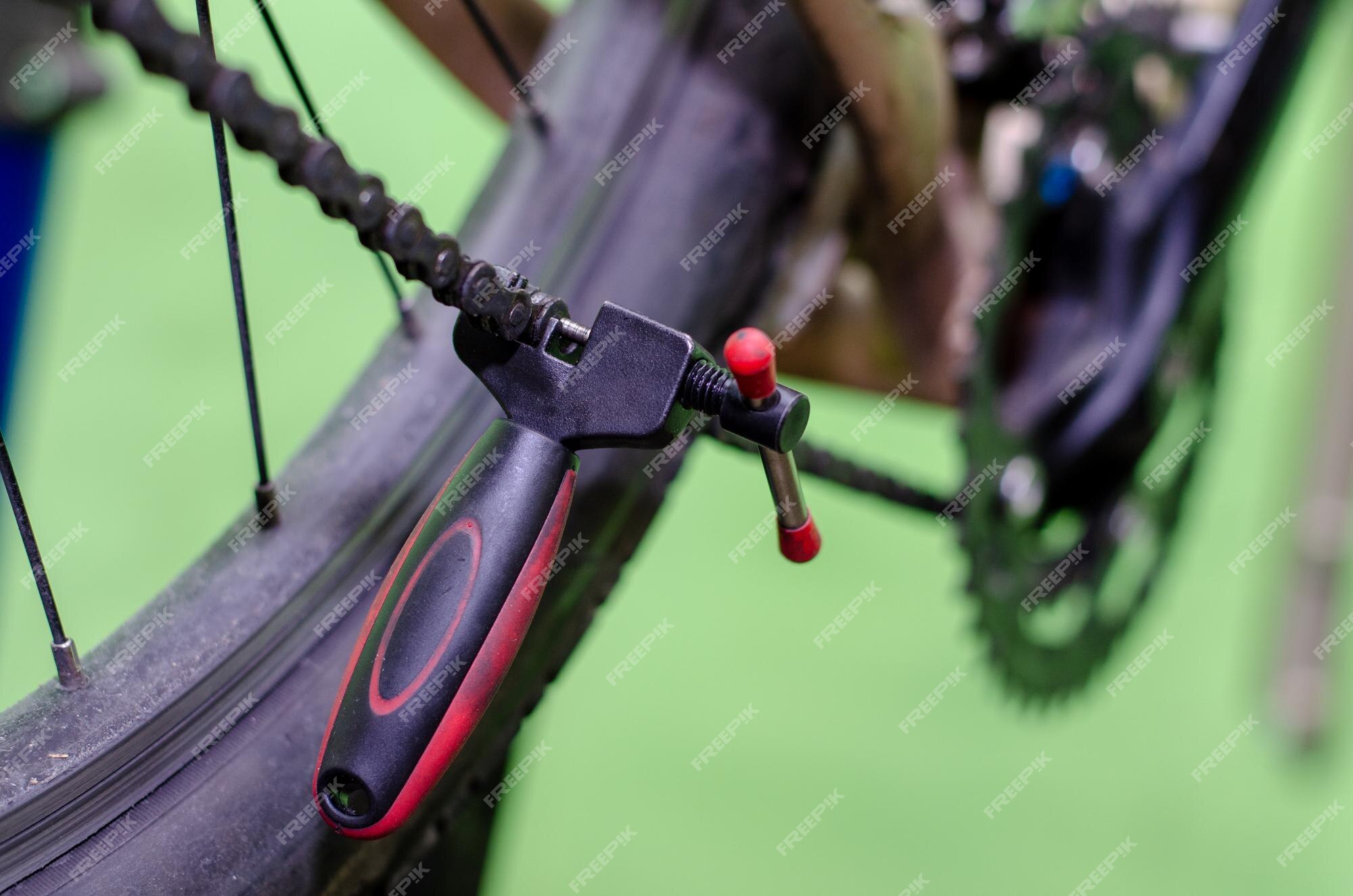 Premium Photo | Repair mountain bike in the workshop replacing an old rusty  chain with a new one tool for make chain removal and installation closeup  green background