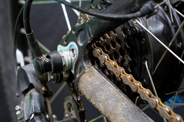 Repair of an old electric bike Dirty and old bicycle chain covered with rust closeup Professional workshop