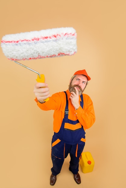 Repair professional painter in protective helmet happy painter
man painter with painting roller