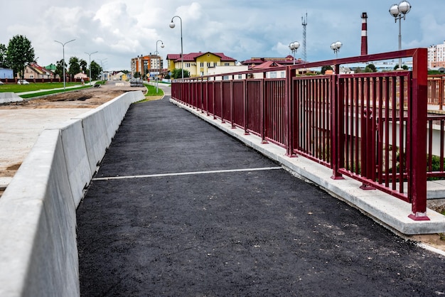 Repair of sidewalk in the city street. Renovation of the road. New asphalt pavement.