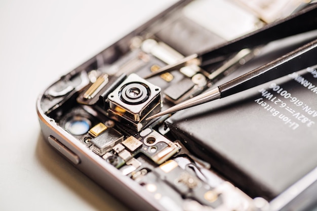 Photo repairing damaged smart phone in service center closeup