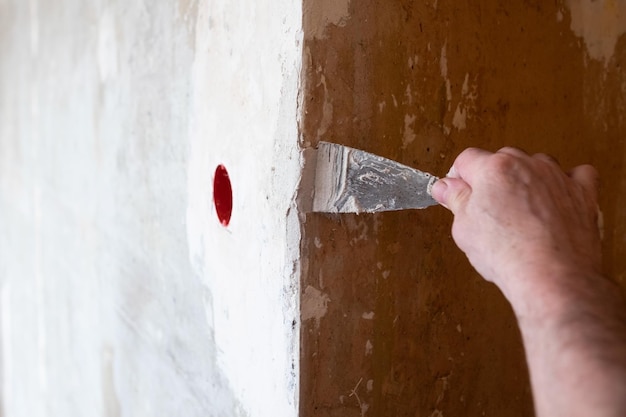 Repairing the wall  man putting spackle on a hole in the wall