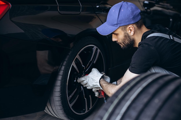 Repairman at car service changing tires