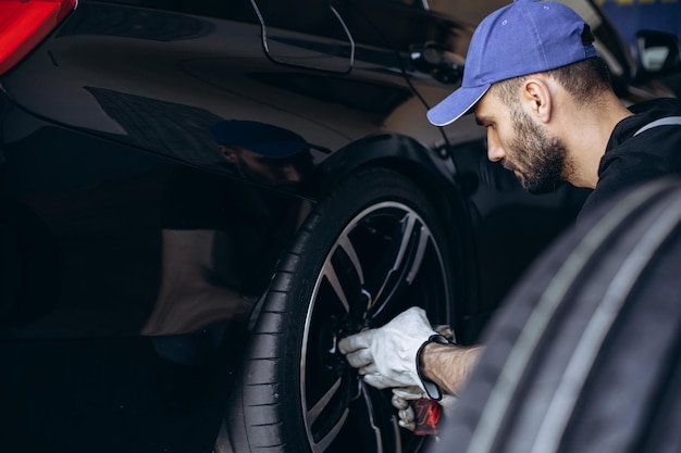 Repairman at car service changing tires